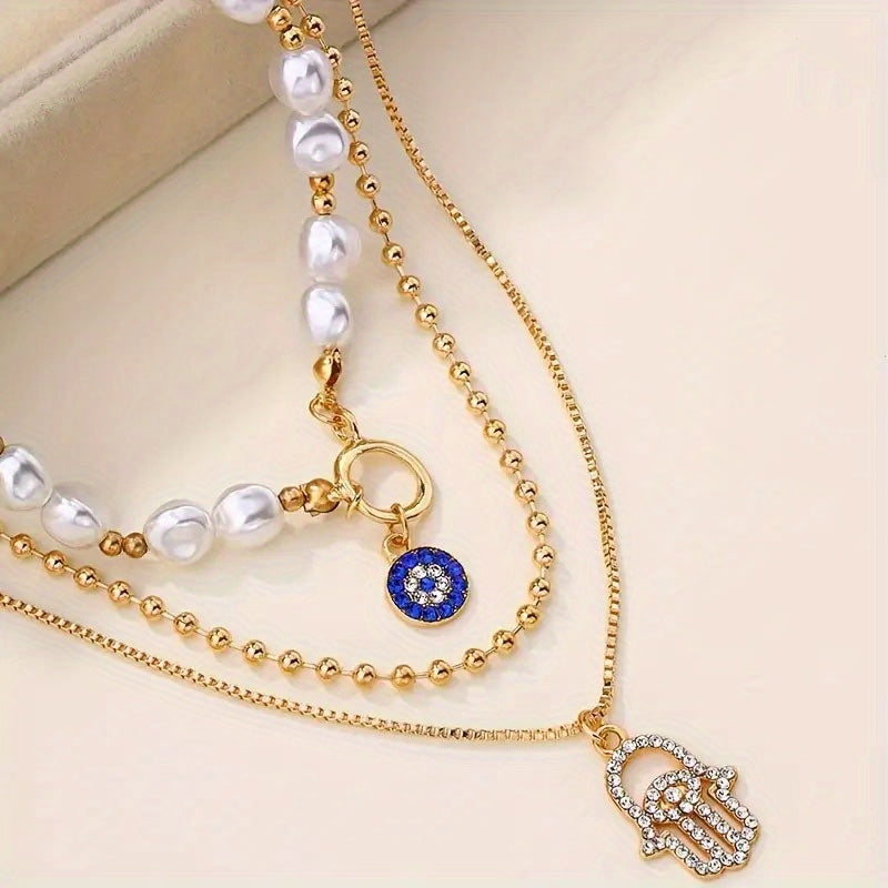 14K Gold Plated Layered Pearl Necklace – Evil Eye & Hamsa Charm Multi‑Layer Pendant for Women on a neutral background