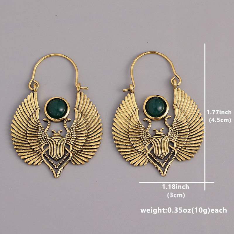 Gold-plated Egyptian goddess dangle earrings with winged design and size measurements shown on a gray background.