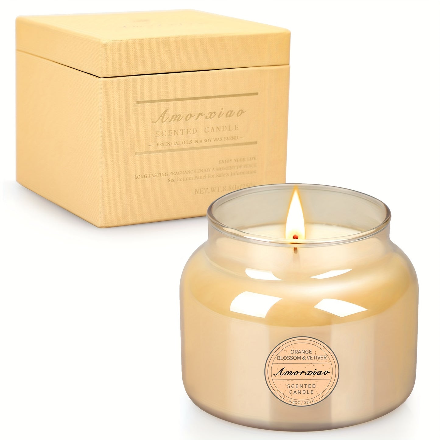 Orange blossom and vetiver scented candle in glass jar with matching gift box, lit candle displayed for modern home decor