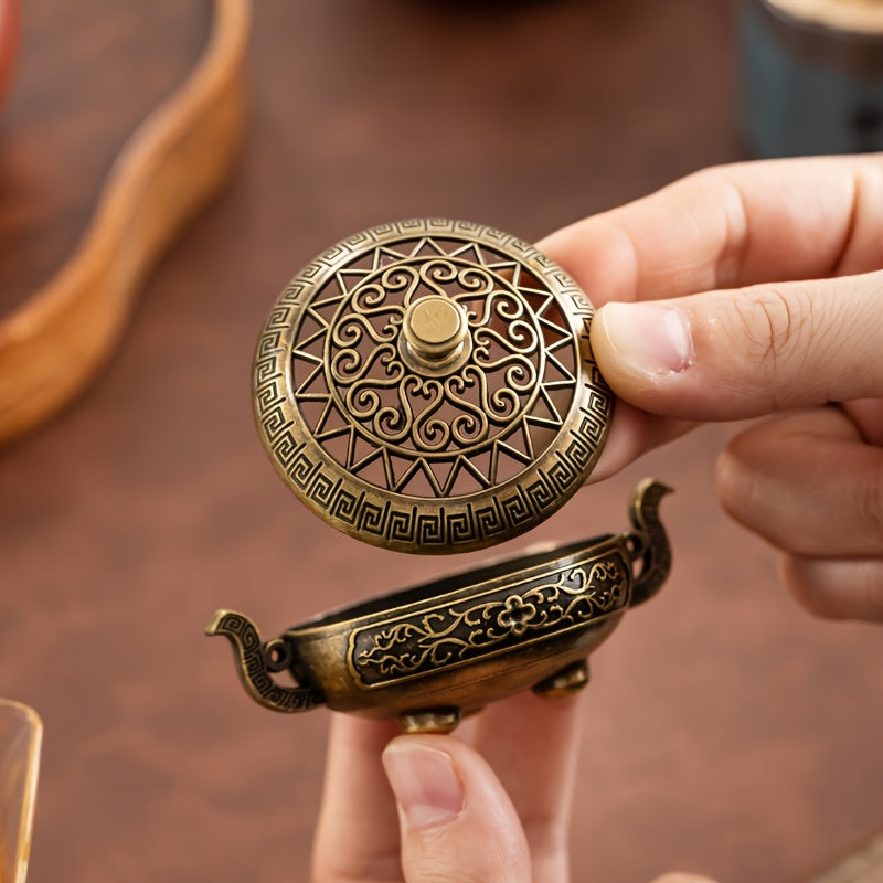 Hand lifting the lid of an antique Style Metal Incense Burner, Double Ear Design with Exquisite Carvings, Hollow Pattern, 3-Legged Base.