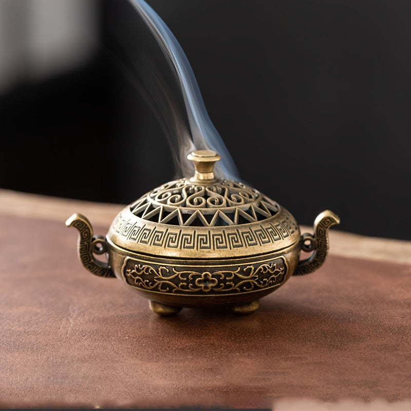 1pc Antique Style Metal Incense Burner, Double Ear Design with Exquisite Carvings, Hollow Pattern, 3-Legged Base for home decor sitting on a table with smoke coming out.