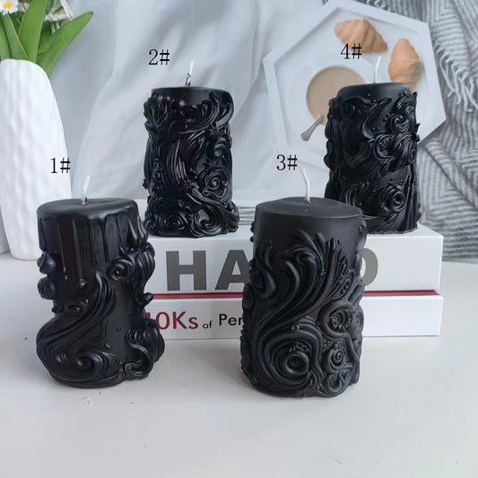 Black sculpted pillar candles with ornate floral and swirl detailing displayed in four design variations on a styled tabletop with books and decor accents