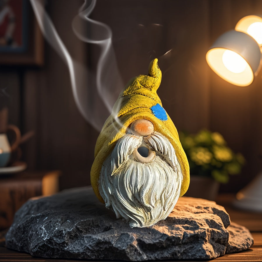 Garden gnome resin incense burner with hole for the mouth, and pointed hat sitting on a rock surface with smoke coming out of it's mouth. For home decor.
