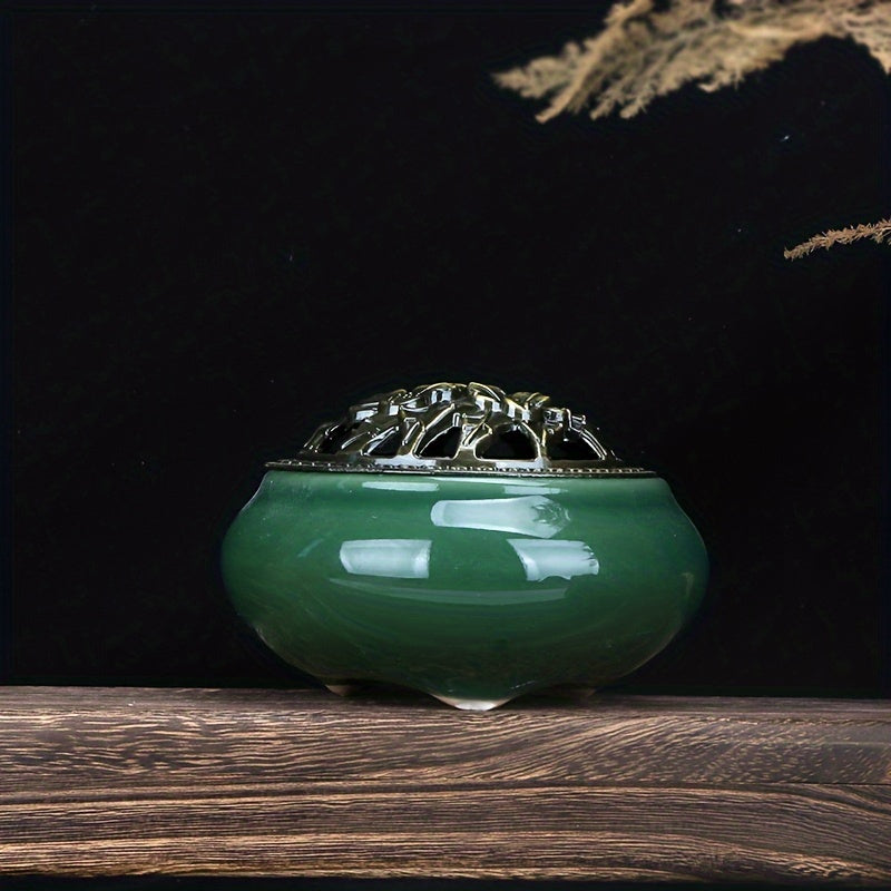 Green ceramic incense burner with decorative metal lid on, displayed on a wooden surface against a dark background for elegant home decor styling
