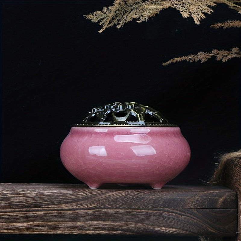 Pink ceramic incense burner with decorative metal lid displayed on a wooden surface against a dark background for elegant home decor styling