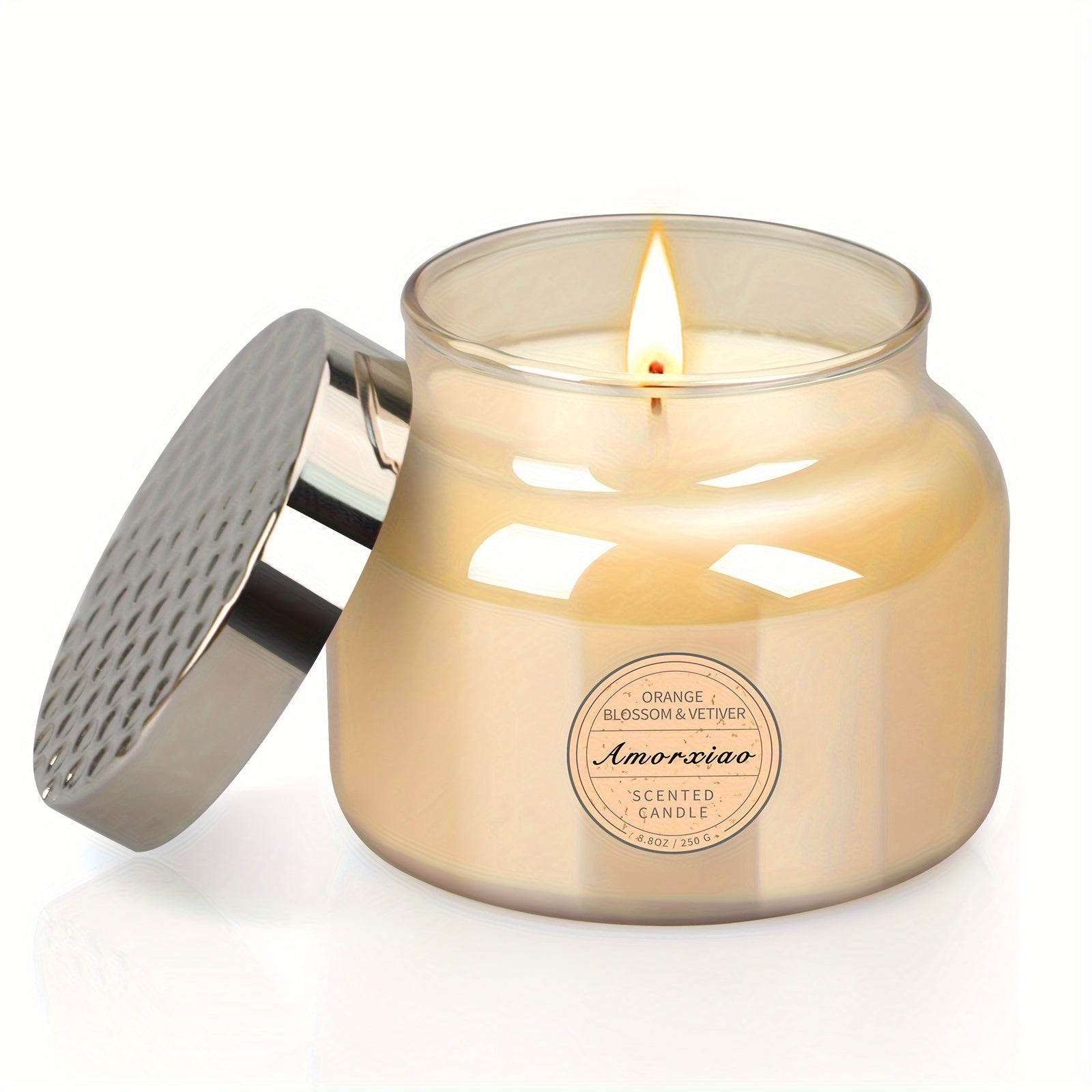 Orange blossom and vetiver scented candle in clear glass jar with metal lid removed, lit candle shown for modern home decor