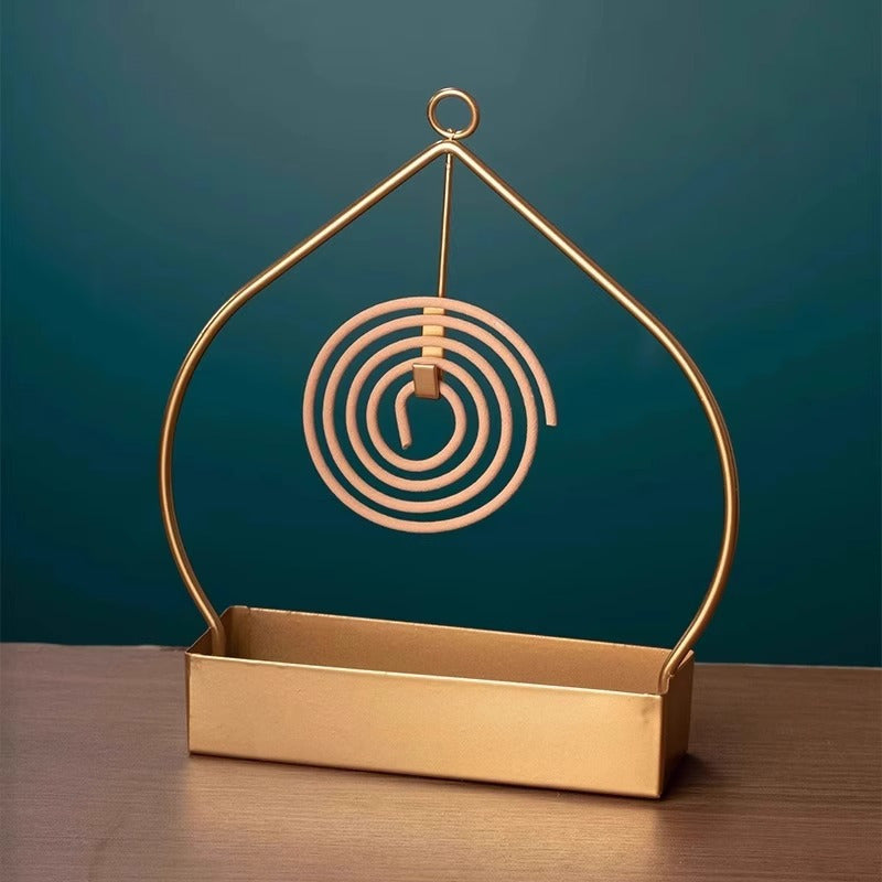 Single metal incense burner tray teardrop shaped with suspended spiral coil holder and rectangular ash base.
