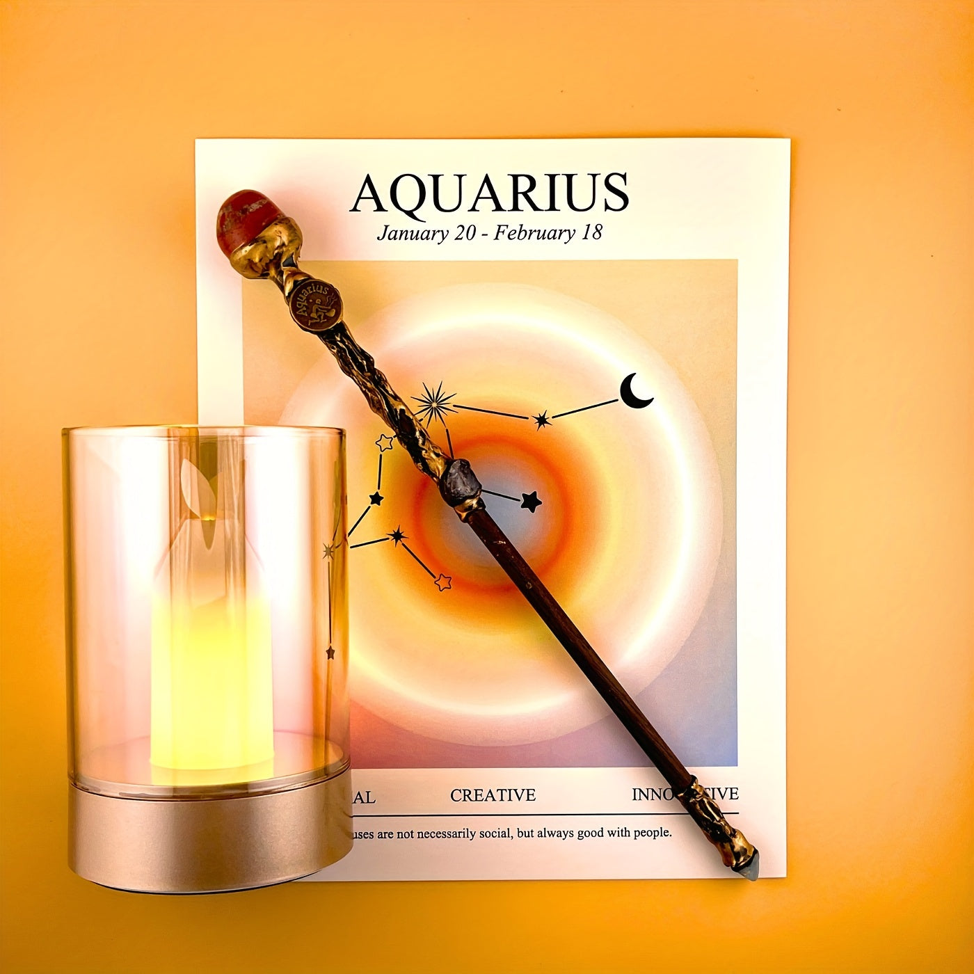 Aquarius zodiac art print with constellation design displayed beside a glass candle holder and decorative astrology wand on a warm yellow background