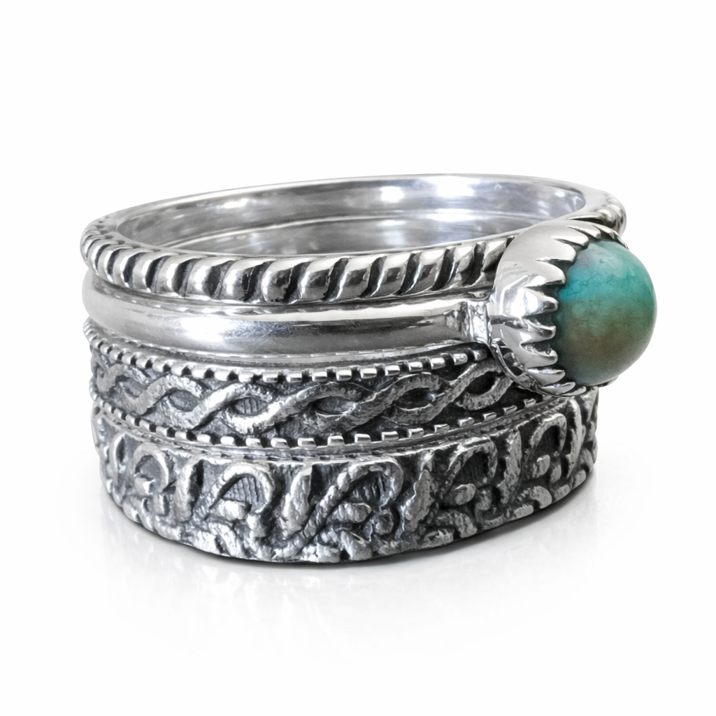 Set of four sterling silver rings with intricate designs on a white background