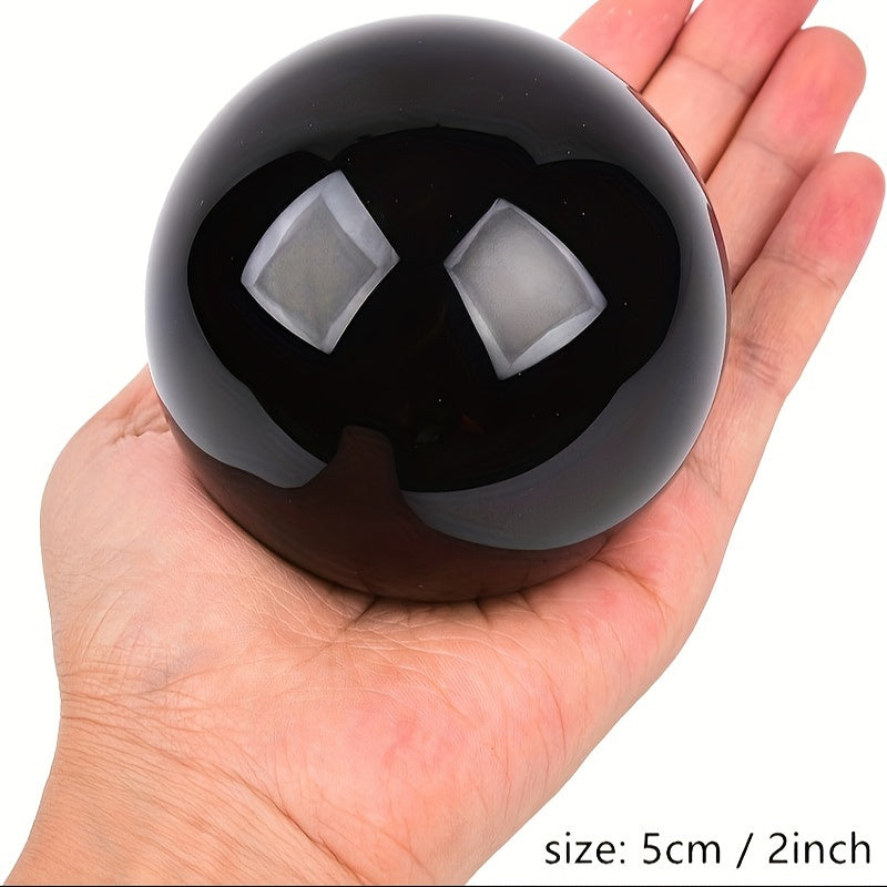 Black sphere on a textured white surface with a blurred background
