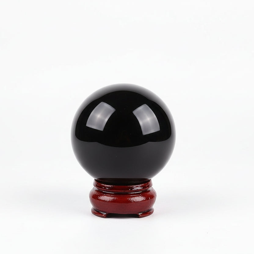Black crystal ball on a red stand with a blurred background