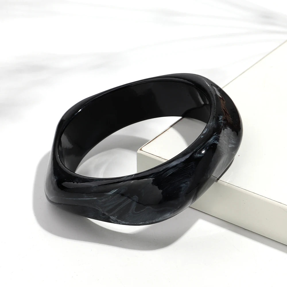 Black ceramic bangle on a white surface