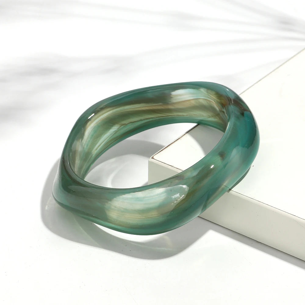 Green glass bangle on a white surface