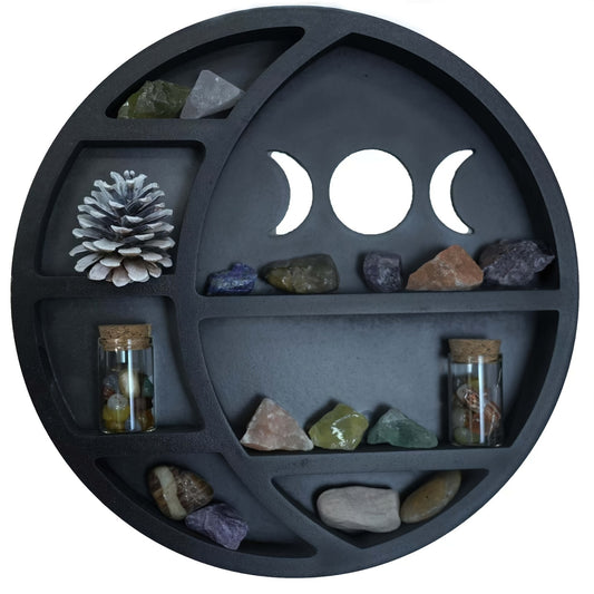 Round black tray with compartments containing stones, crystals, and a pine cone, featuring a central design of moon phases.