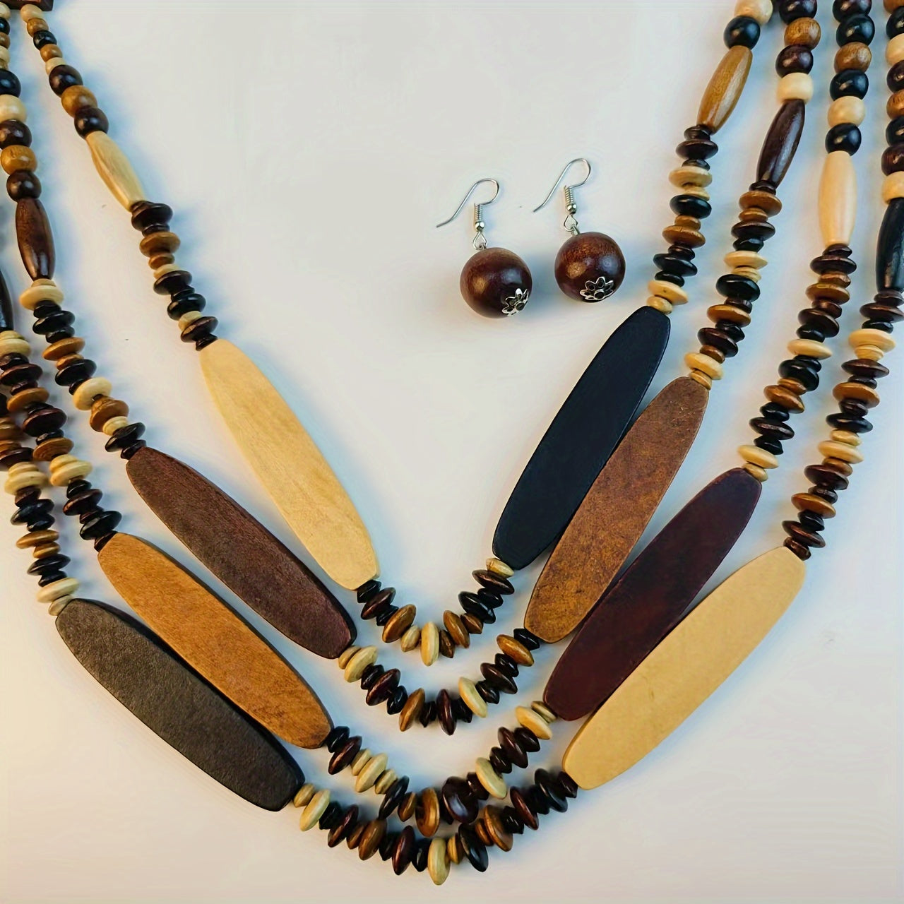 Necklace and earrings with wooden beads on a light background