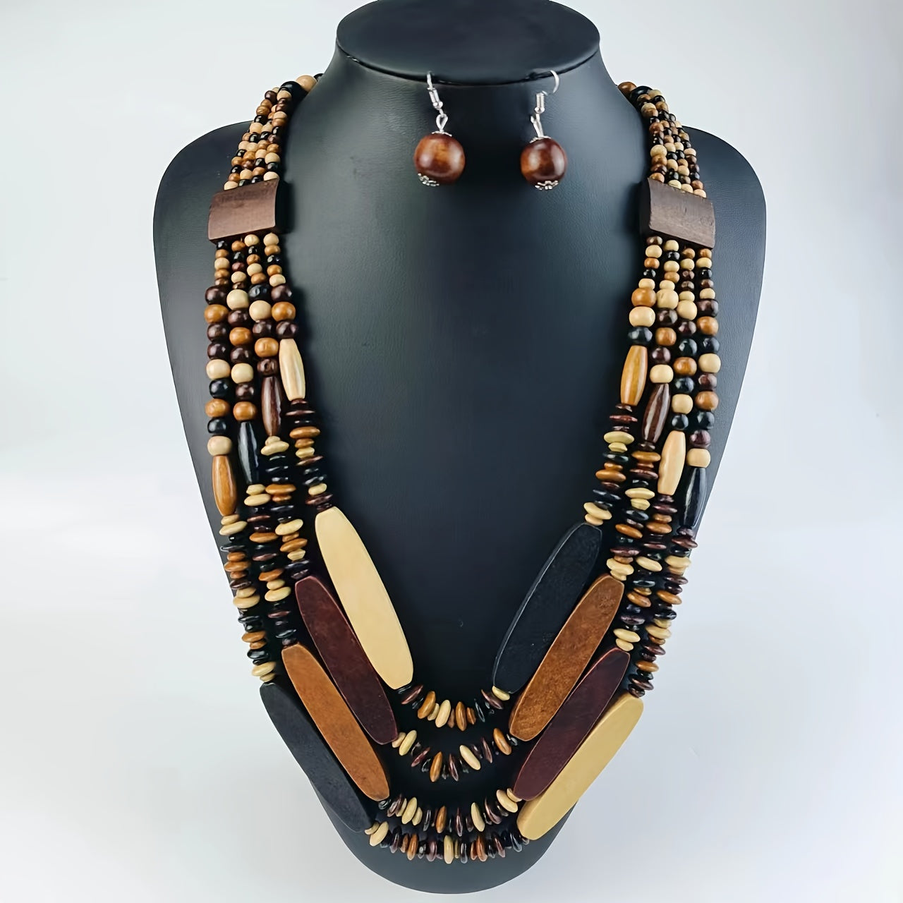 Wooden bead necklace and earrings on a black mannequin with a white background