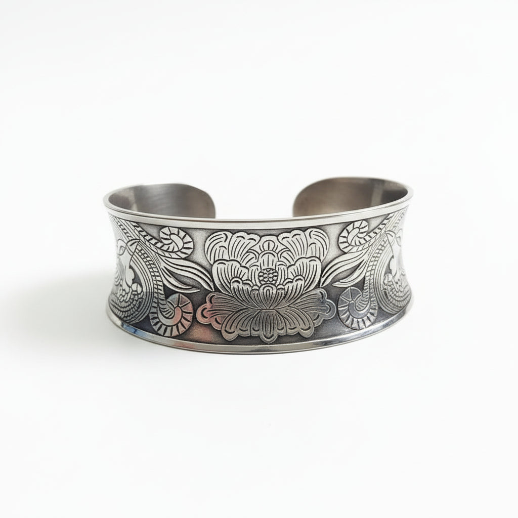 Silver bracelet with floral patterns on a wooden stand against a dark background