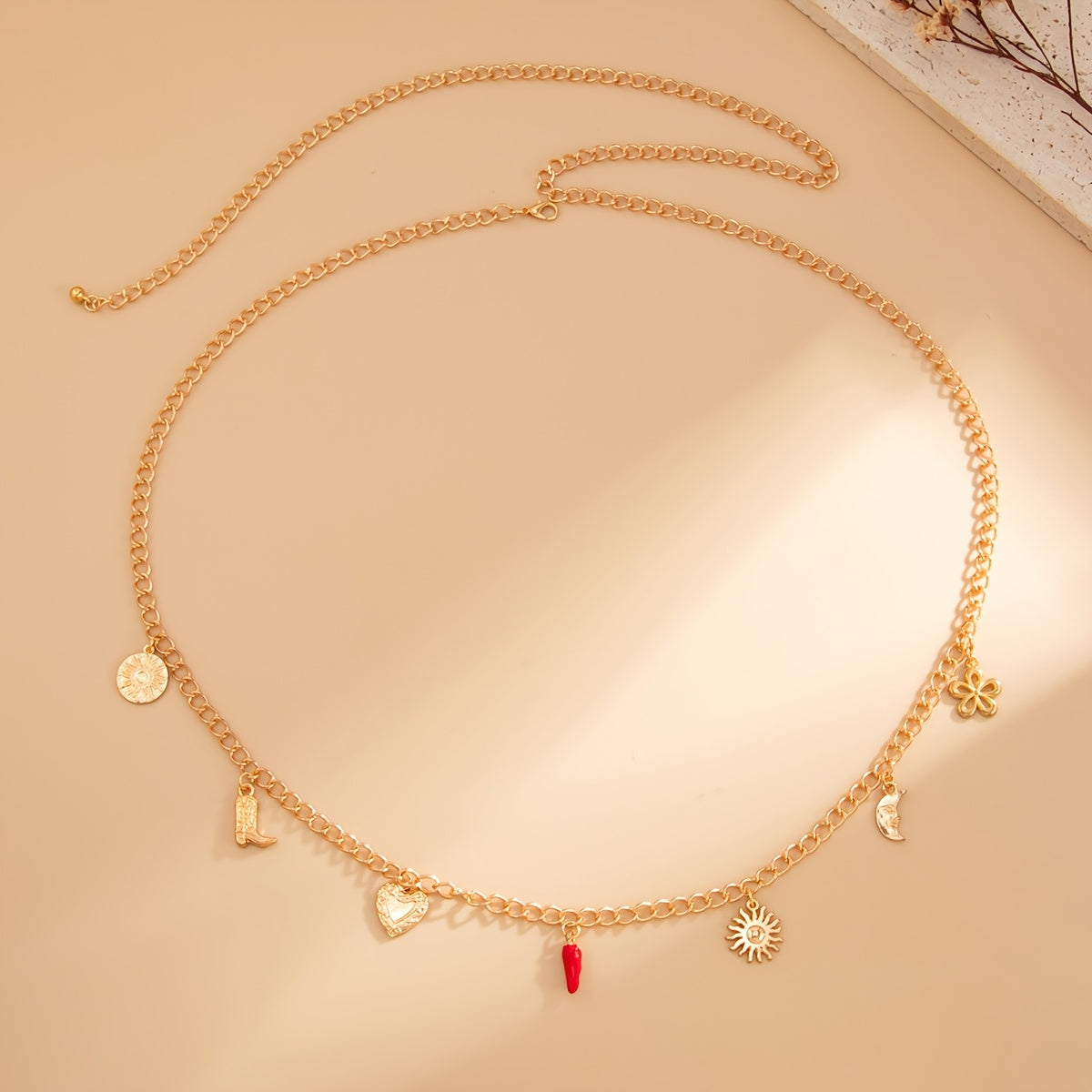 Boho gold charm waist chain with sun heart moon boot floral charms and red accent drop on polished gold tone chain