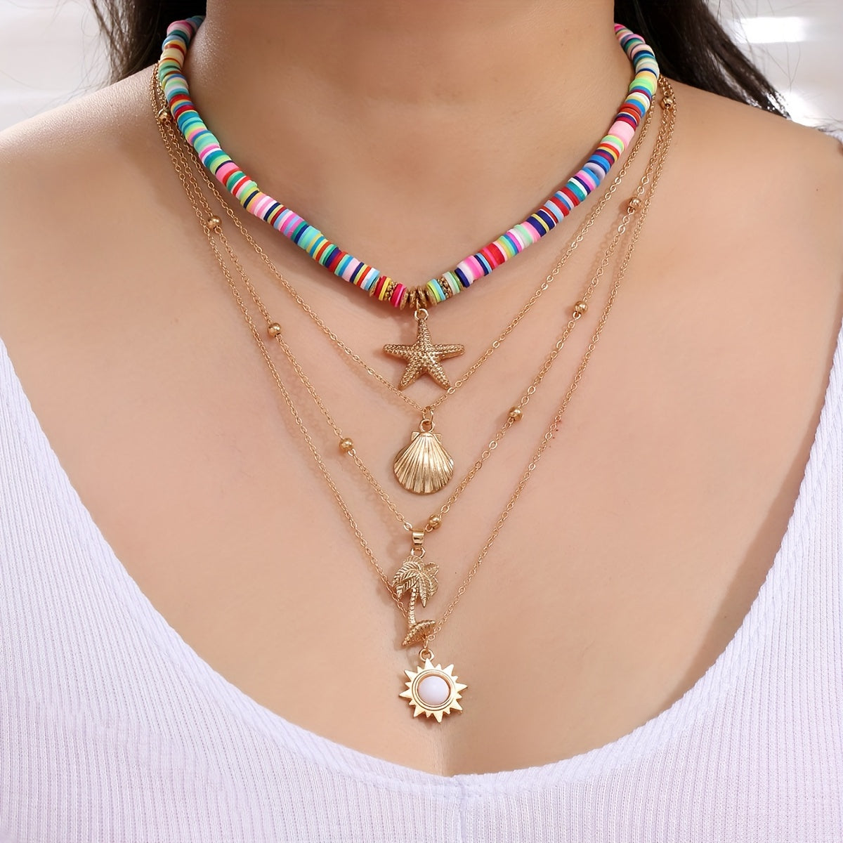 Colorful beaded necklace with star, shell, and sun pendants being worn