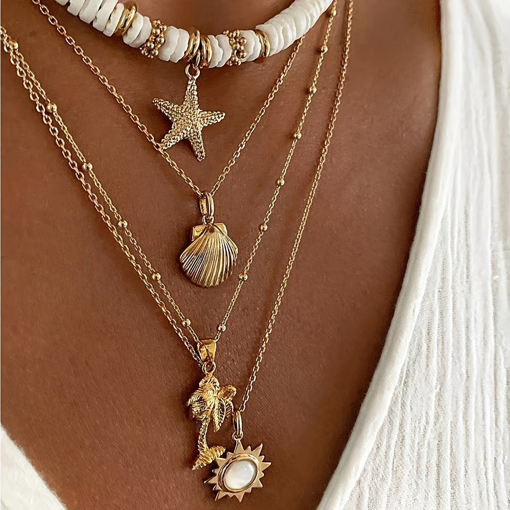 Necklace with starfish, shell, palm tree, and sun pendant on a person's neck.