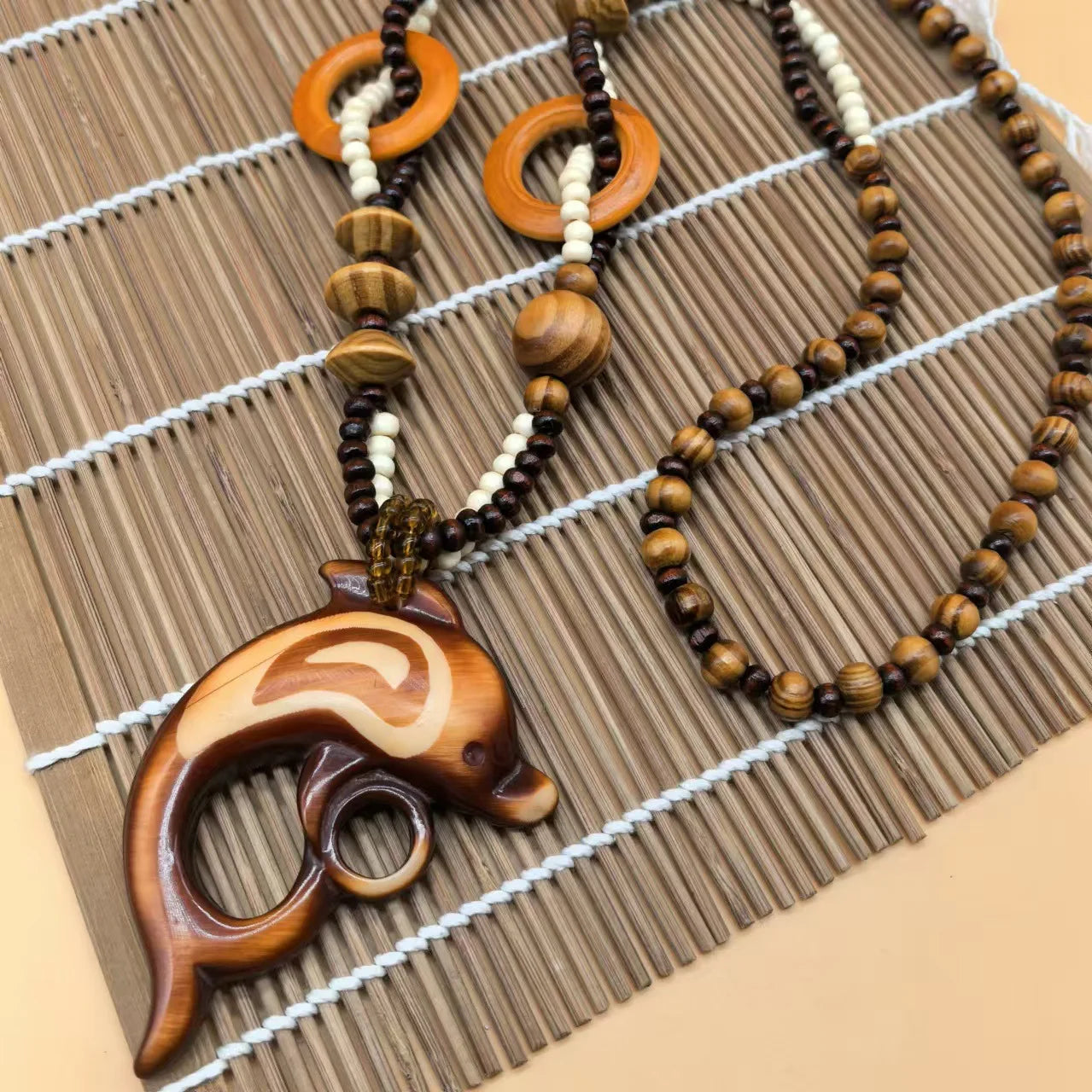 Wooden necklace with a unique dolphin pendant on a woven mat