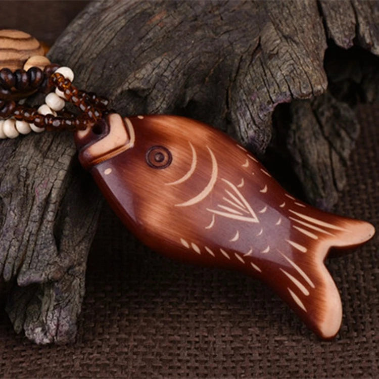 Wooden fish-shaped object with carvings on a textured brown background