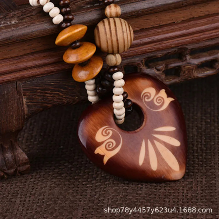 Heart shaped Wooden pendant with bead necklace on a textured wooden background