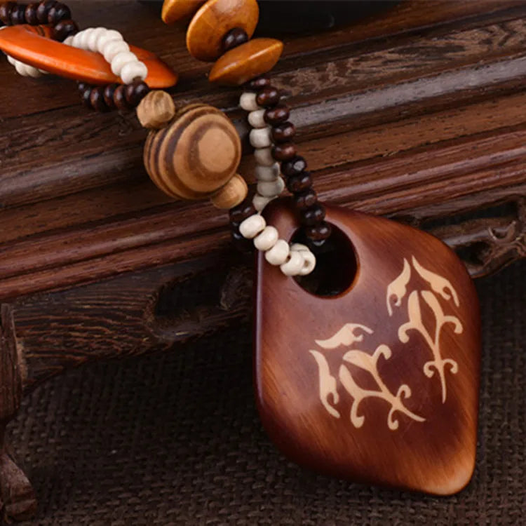 Wooden pendant with engraved design on a wooden background