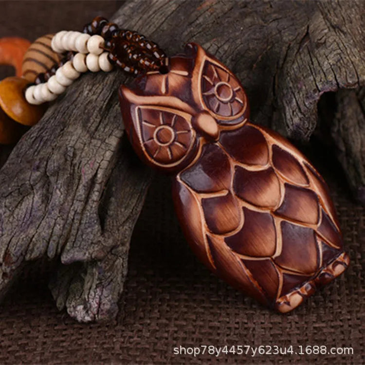 Wooden owl pendant on a textured surface