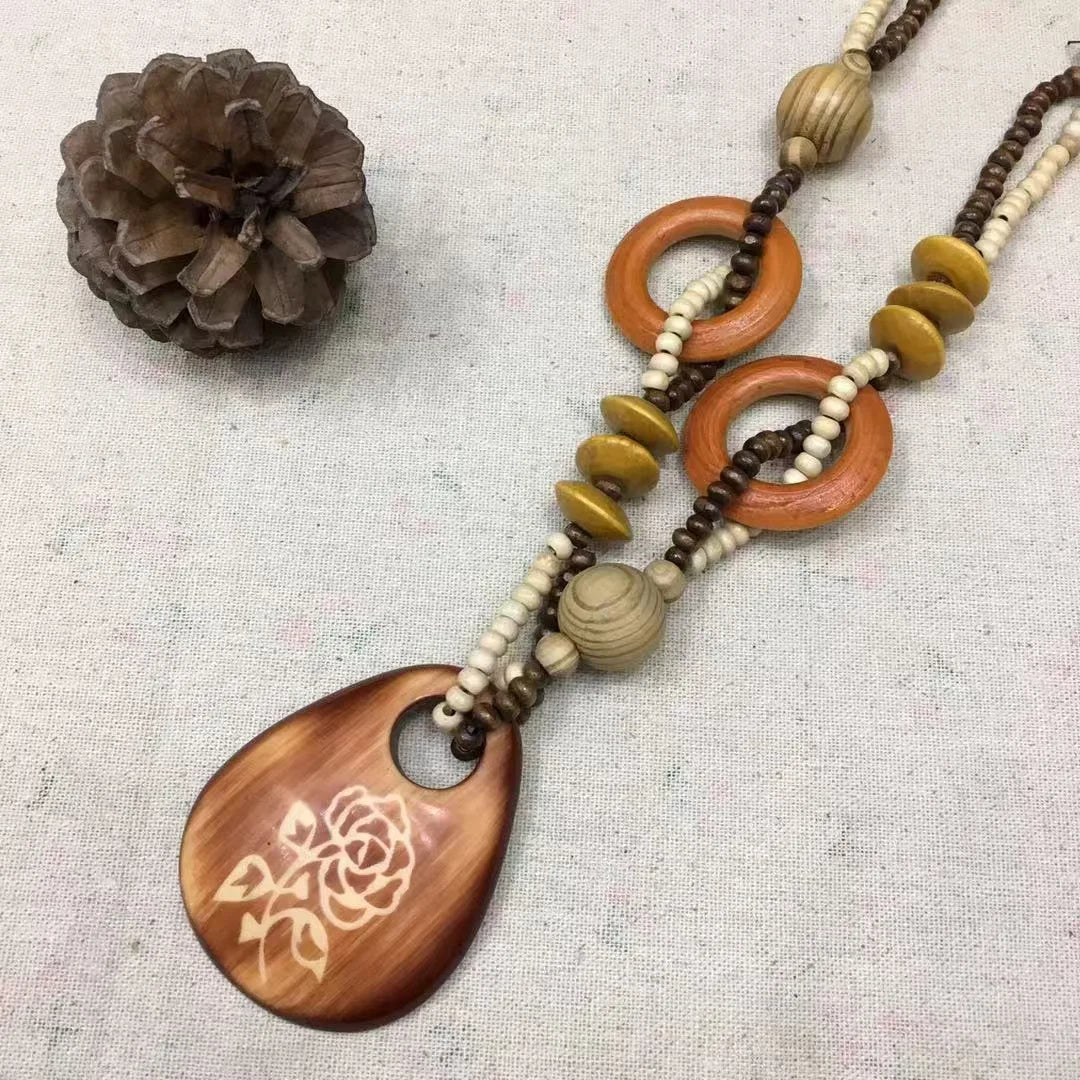 rose pattern Necklace with wooden pendant and beads on a textured surface