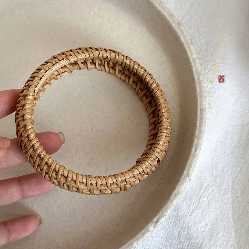 Hand holding a woven bracelet on a light background