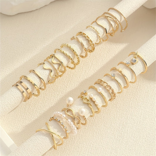 Set of gold and pearl rings on a beige fabric background