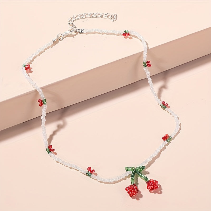 Necklace with floral beads and cherry  on a beige background