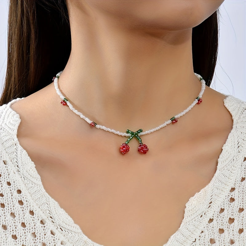 Necklace with cherry pendant on a model wearing a white lace top