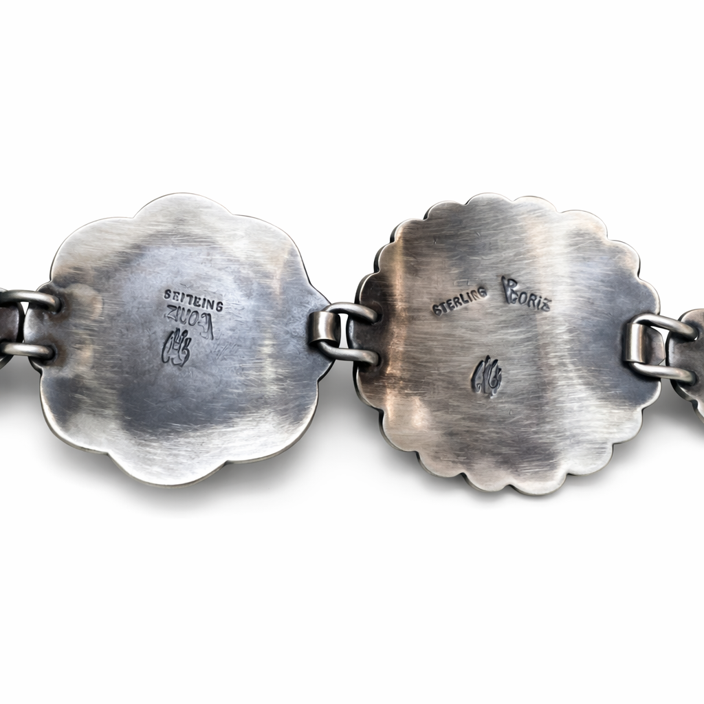 Close-up of a silver bracelet with engraved hallmark V Coriz sterling on a white background