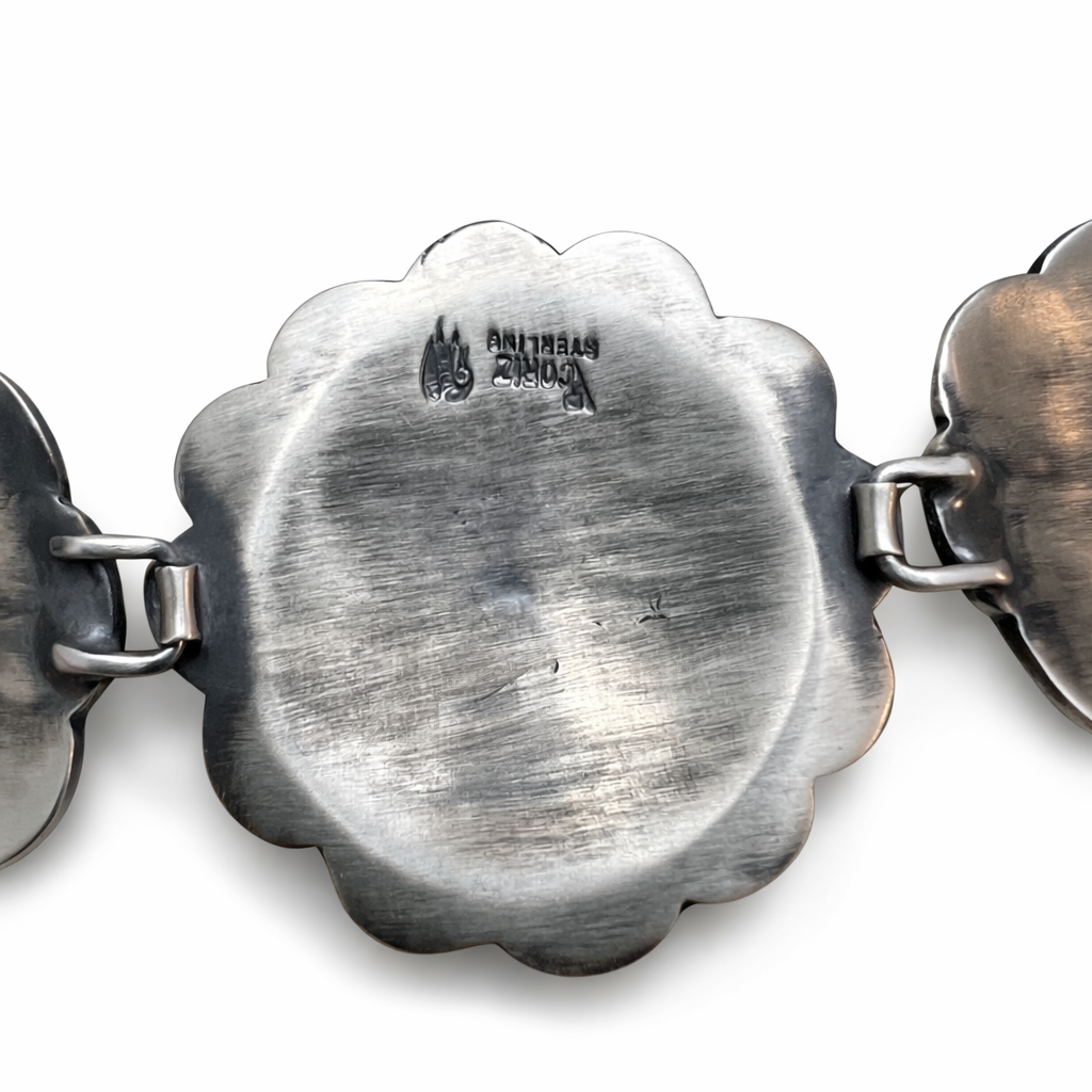 Close-up of a silver bracelet with V Coriz Sterling hallmark on a white background