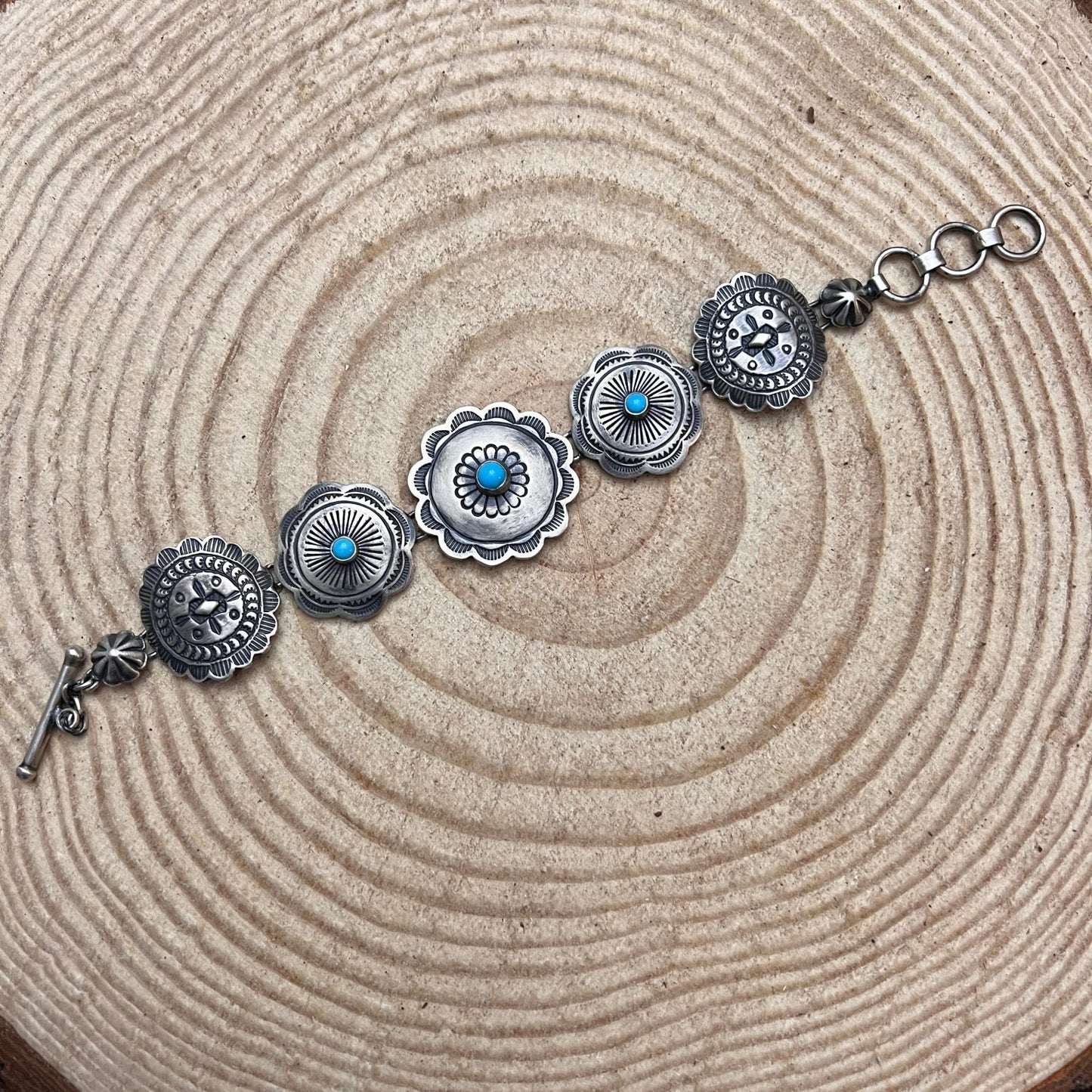 Silver bracelet with turquoise stones on a wooden surface - Clover's Charm