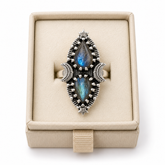 Sterling silver celestial statement ring with two pear-shaped labradorite cabochons displayed in a soft linen jewelry box on a white background -Clover's Charm.