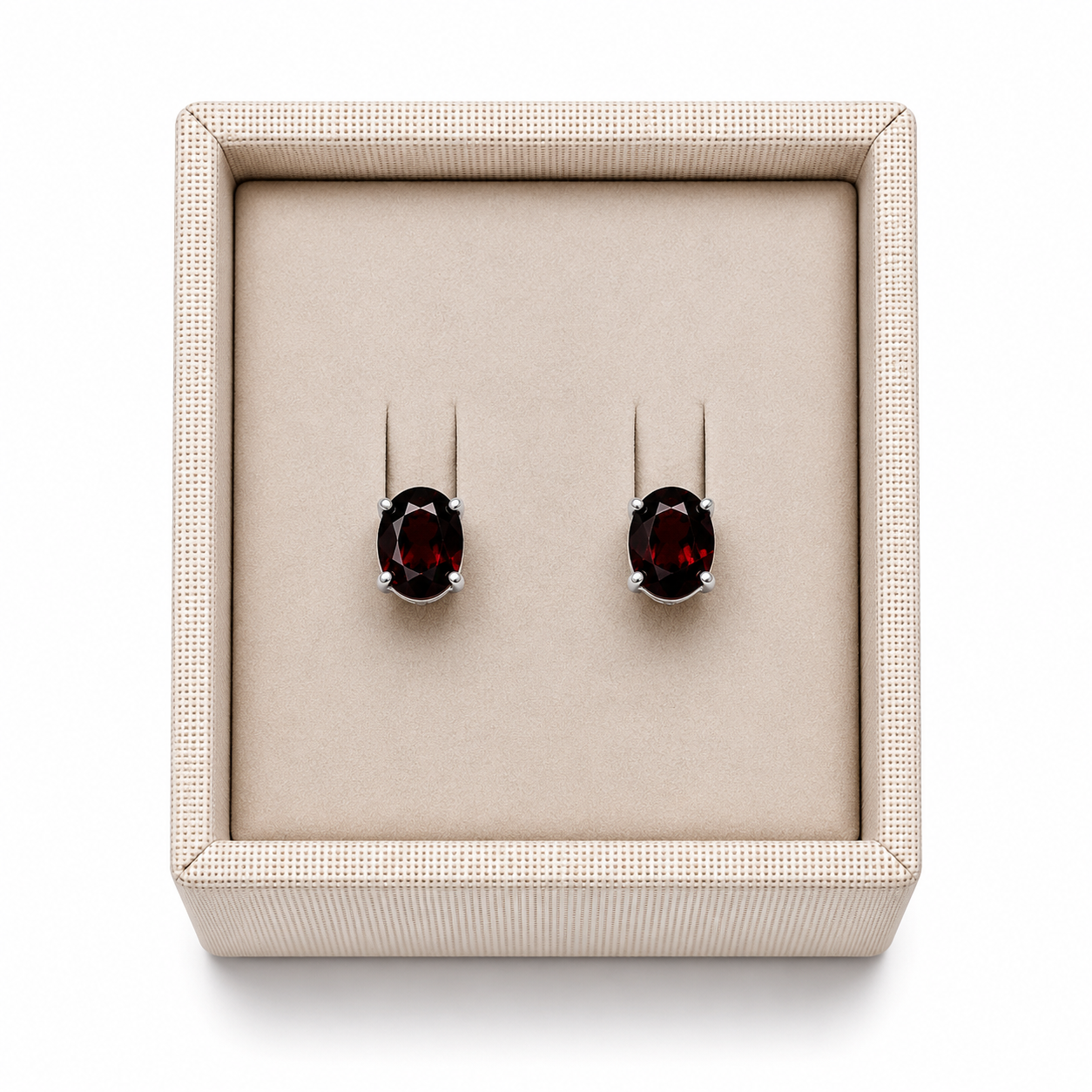 Garnet sterling silver oval stud earrings in a display box on a white background. - Clover's Charm