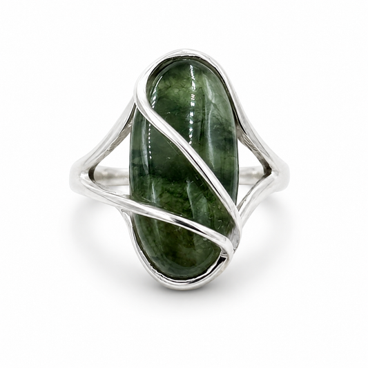 Sterling silver wire-wrap ring with an oval green cabochon gemstone displayed in a soft linen-colored jewelry box -Clover's Charm.