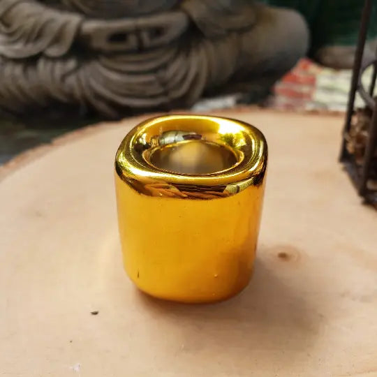Gold-colored object on a wooden surface with a blurred background 
- Clover's Charm