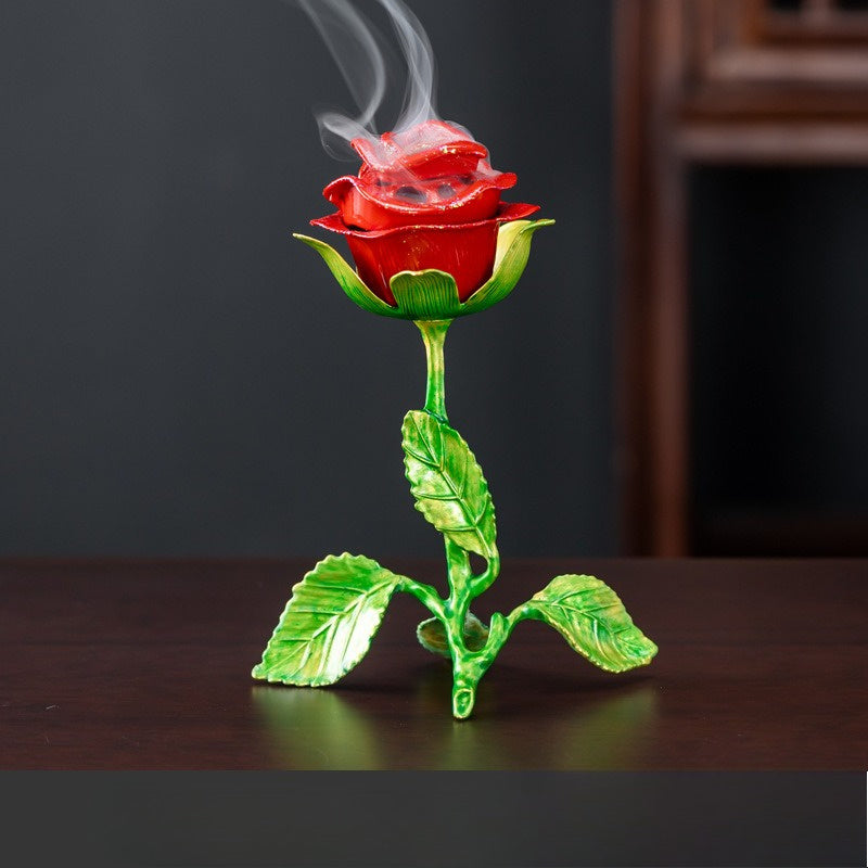 Metal rose incense holder displayed on tabletop with decorative incense smoke
