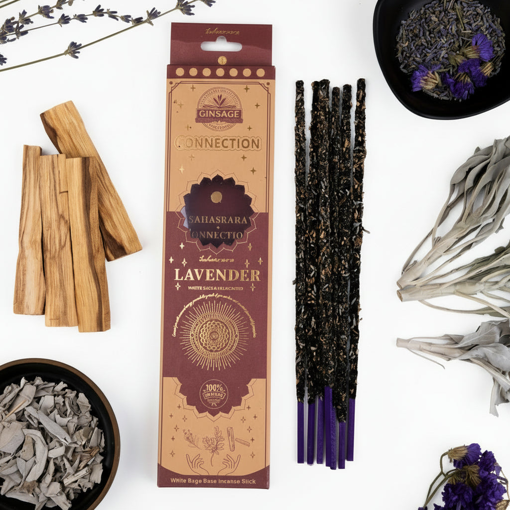 Incense sticks with packaging on a white surface, surrounded by dried herbs and flowers.