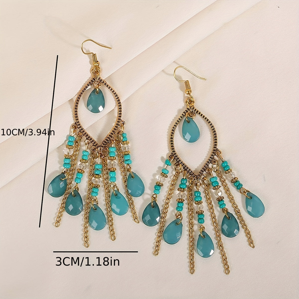 Turquoise teardrop earrings with gold accents on a beige background with measurements displayed