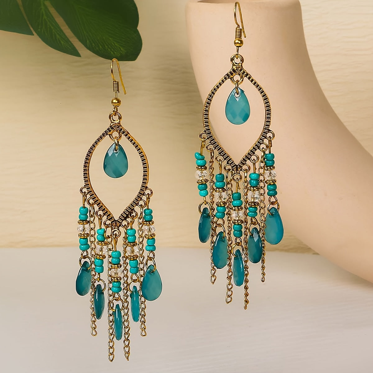 Turquoise beaded earrings with gold accents on a neutral background