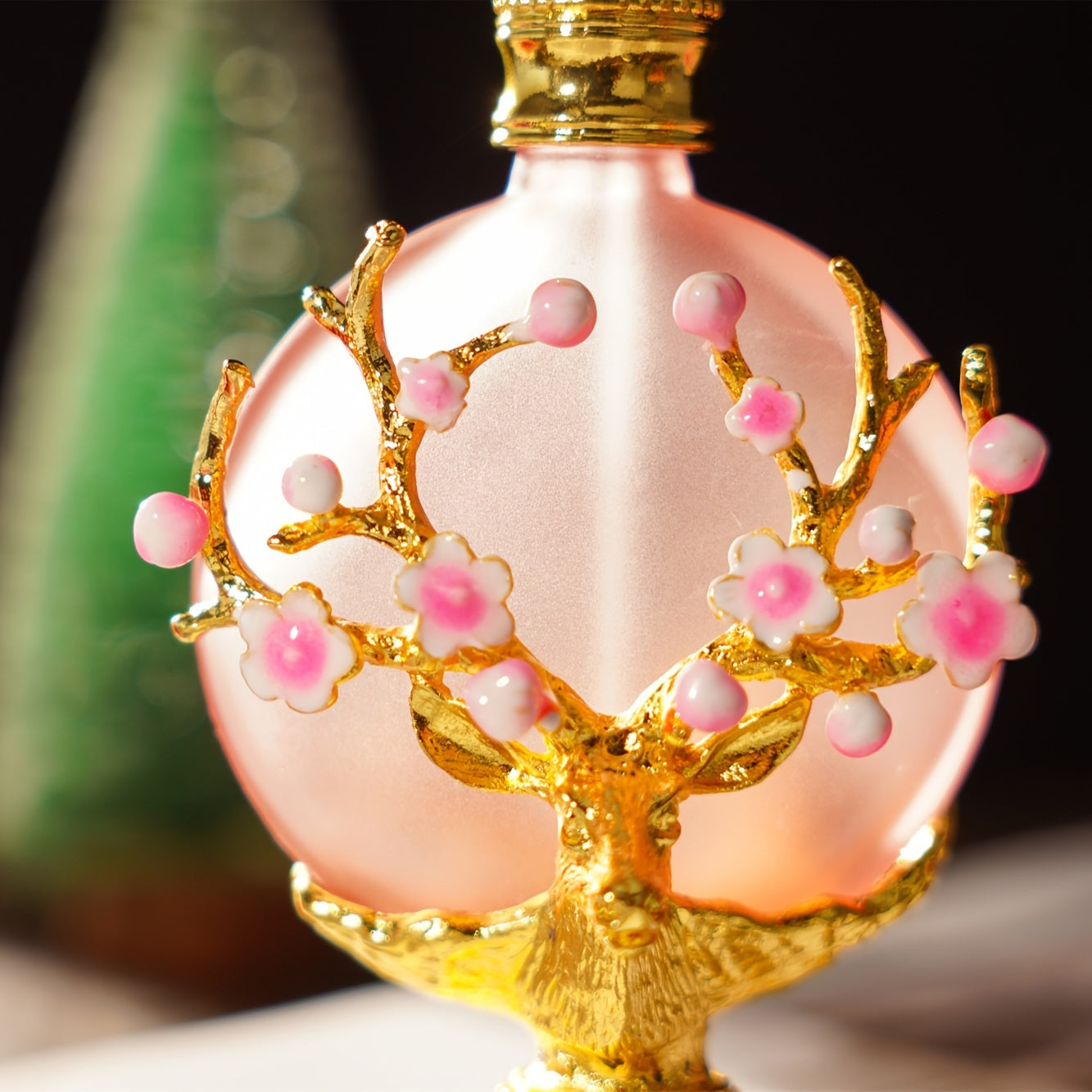 30ML Elegant Pink Perfume Bottle - Luxurious Artificial Crystal, Refillable, Fancy Glass Design, Brand H&D HYALINE & DORA up close view shows a golden animal with antlers and flowers sprouting from the antlers.