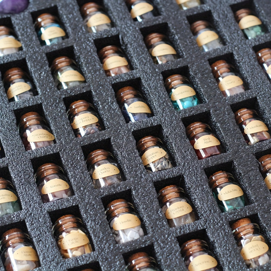 Collection of small bottles filled with gemstones with labels arranged in a grid on a black foam block.