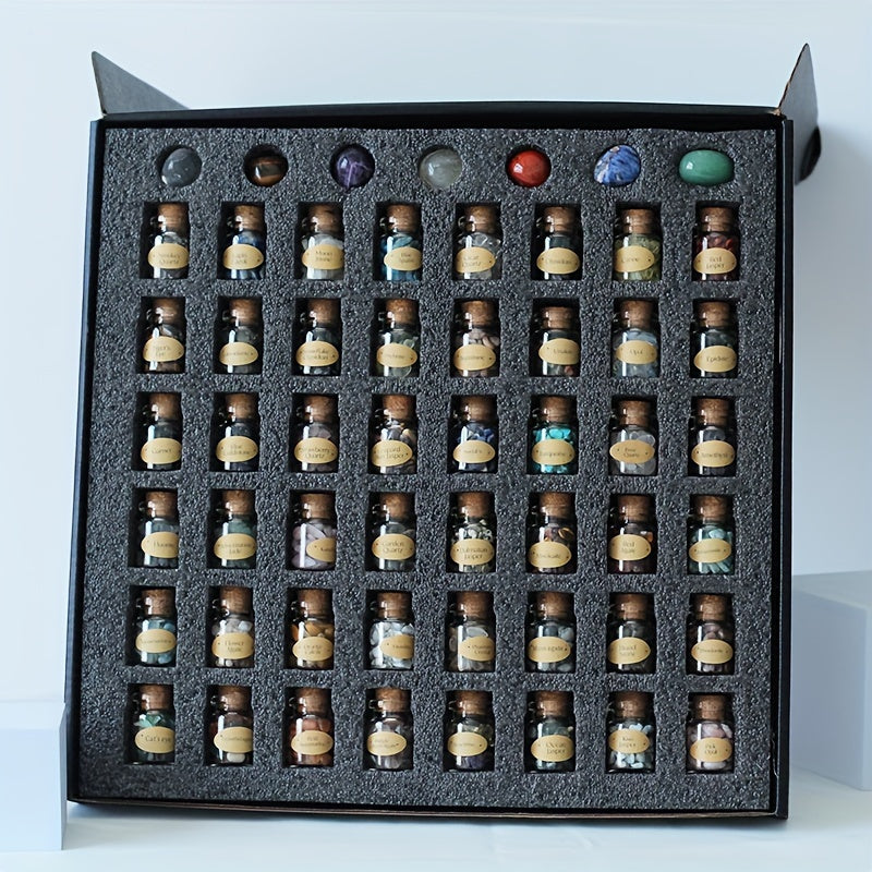 Collection of small bottles with gemstones inside and labels arranged in a grid within a black box.