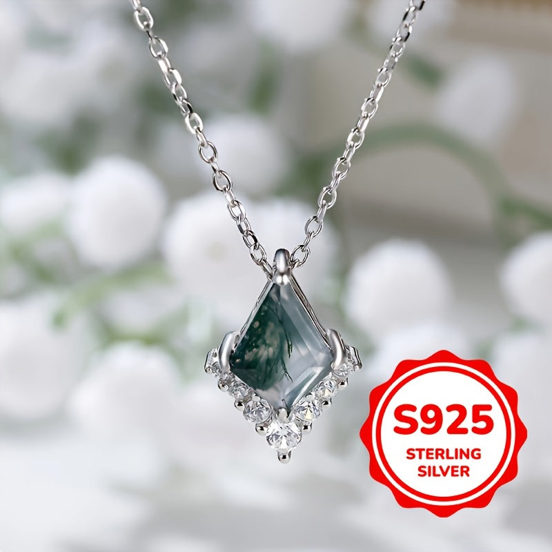 Silver necklace with a green gemstone pendant against a blurred natural background, featuring an 'S925 Sterling Silver' label.