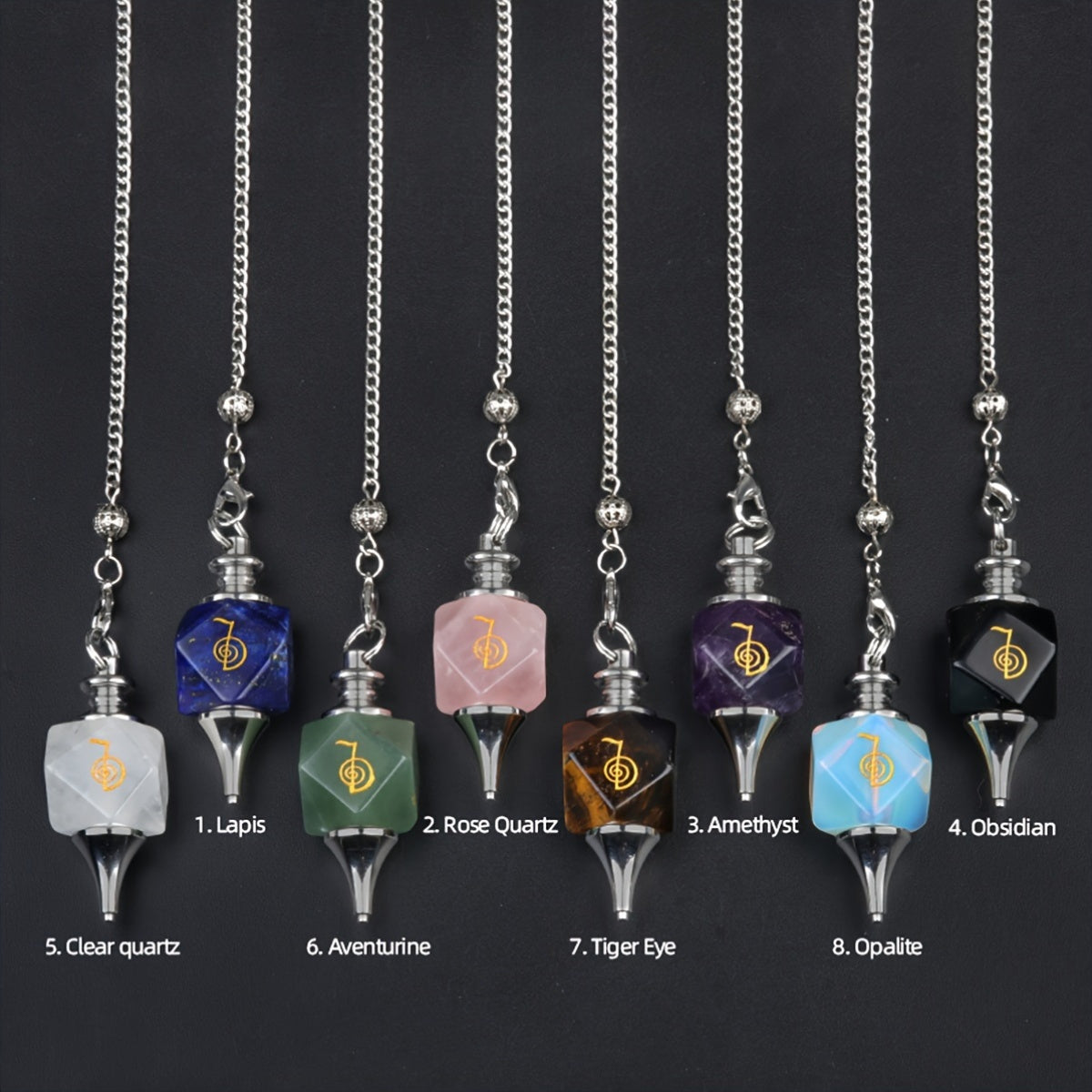 Set of eight crystal pendulums on chains with color labels against a black background